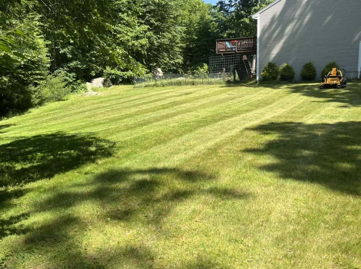 Freshly mowed lawn with clean stripes behind a home, maintained by Jays Property Services LLC